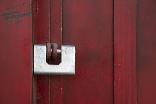 A single lock putted on red door in street.
