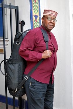 Muslim jazz musician with his saxophone outside.