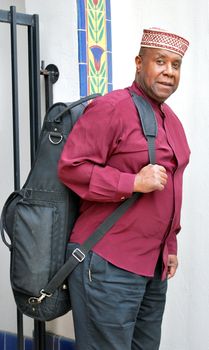 Muslim jazz musician with his saxophone outside.