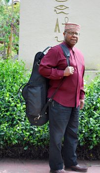 Muslim jazz musician with his saxophone outside.