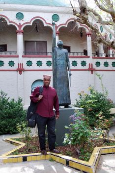 Muslim jazz musician with his saxophone outside.