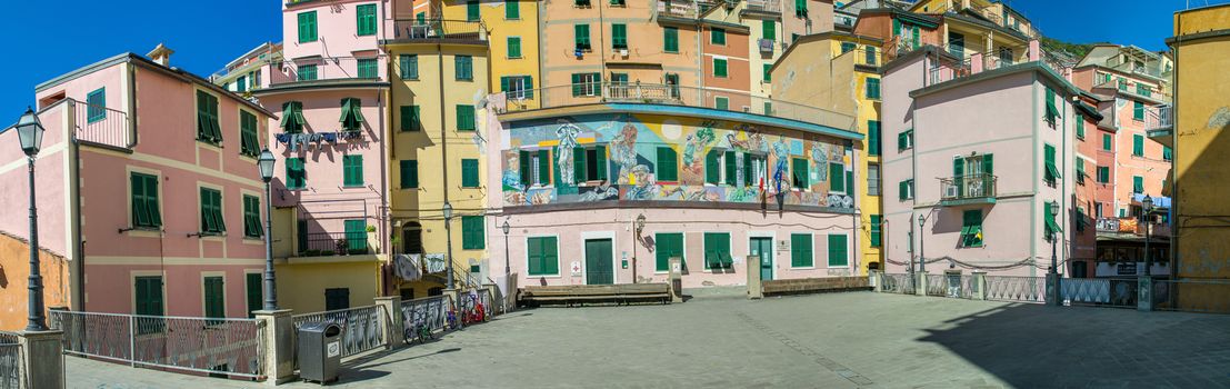 RIOMAGGIORE, ITALY - SEPTEMBER 21, 2014: Colorful city buildings on a sunny day. Riomaggiore is part of Five Lands, one of the major italian tourist destination.