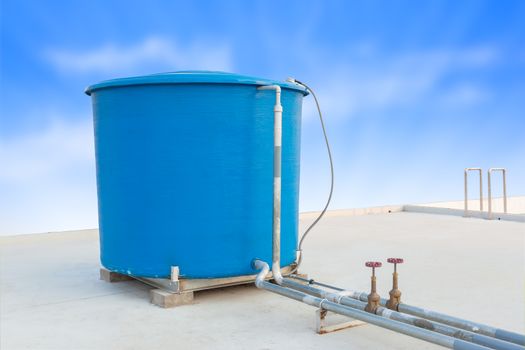 Blue water tank of industrial building on roof top and blue cloud sky background