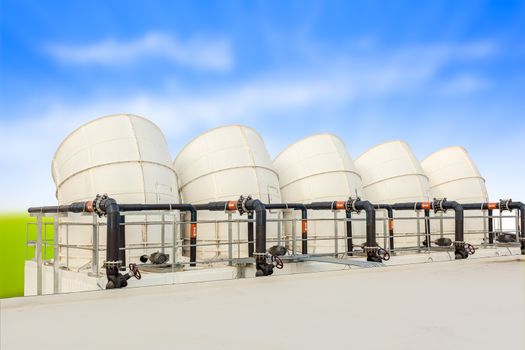 ventilation pipes of industrial building roof top and blue cloud sky background