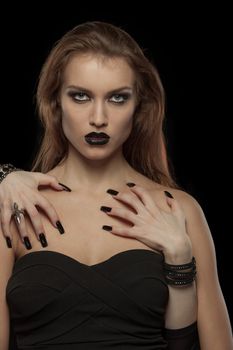 Portrait of a gothic woman with hands of vampire on her body on black background.Halloween