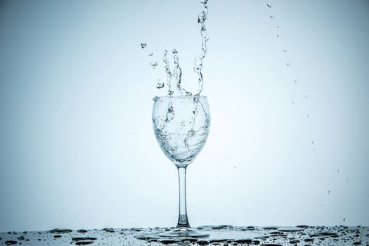 A glass being filled with water on white background