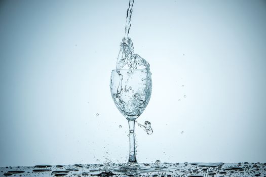 A glass being filled with water on white background