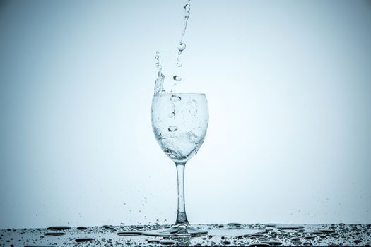 A glass being filled with water on white background