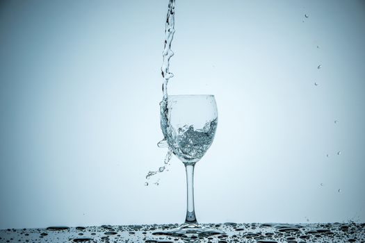 A glass being filled with water on white background