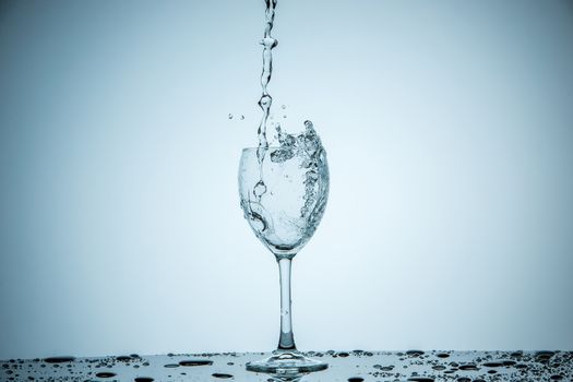 A glass being filled with water on white background