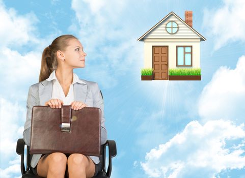 Businesswoman sitting in the chair and looking to the right at house on blue sky background