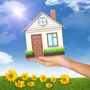 House on businesswomans hand on nature background with flowers