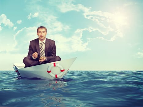Businessman sitting in lotus position in paper boat in sea and looking at camera