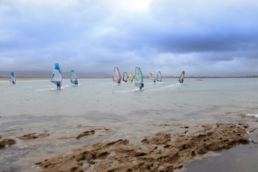 wind surfers racing in the storm winds on the wild atlantic way in county Kerry Ireland near rocks