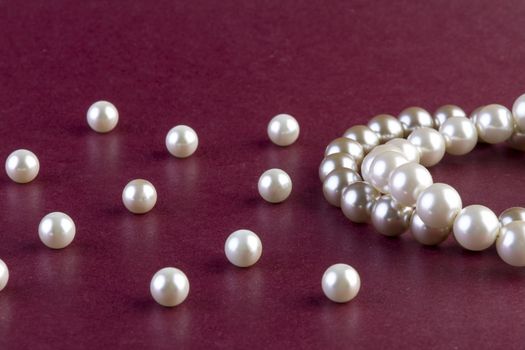 Silver and White pearls necklace on dark red background