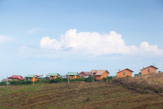 Homes built on a mountain resort. The resort is built on a hill. Behind the clear sky