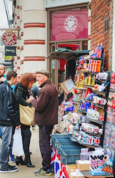 LONDON - APRIL 13: Street souvenir shop with tourists on April 13, 2015 in London, UK. London is a popular centre for tourism, one of its prime industries, employing the equivalent of 350,000 full-time workers.
