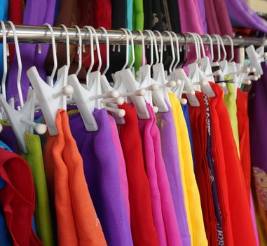 Women dressed in various colors hanging on the iron railing.                                