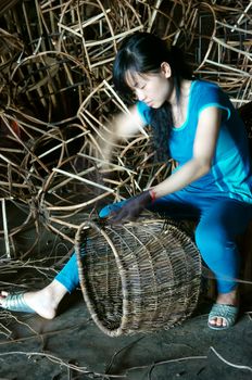 LAM DONG, VIET NAM- MAY 1: Vietnamese worker working inside of home at trade village  to make traditional product, rattan basket from nature material, clever hand, Vietnam, May1, 2015