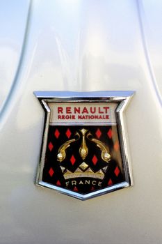 Logo Renault 1960 on the hood of a gray Dauphine Gordini photographed vintage car rally on City Hall Square in the city of Ales in the Gard department.