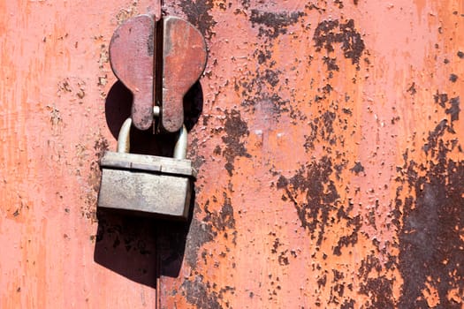 scratched orange metal surface with handle and lock