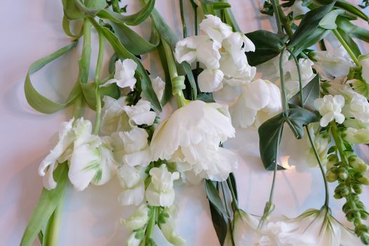 Assorment of white and green flowers laid out on a white surface