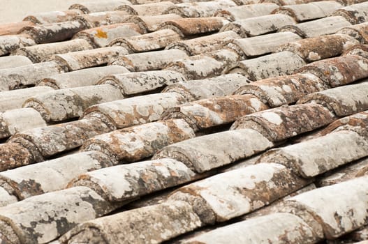This is a close-up view of an old roof with red tile