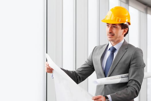 businessman in construction helmet with blueprints