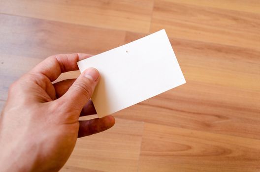 Man hand hold note with wood table office background
