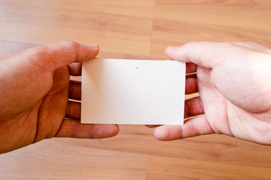 Man hands hold note with wood table office background