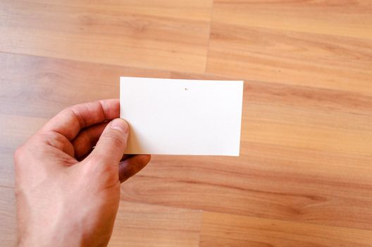 Man hand hold note with wood table office background