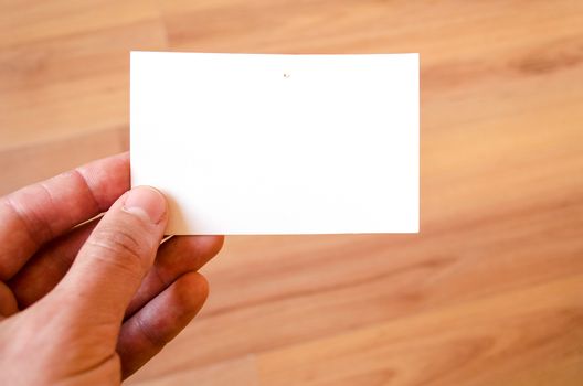 Man hand hold note with wood table office background