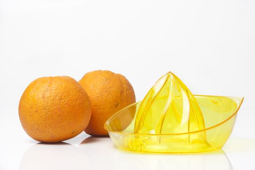 Fresh made orange juice set with oranges and juicer.
High key and soft shadows