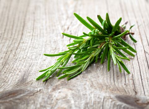 Twigs of rosemary on wooden texture