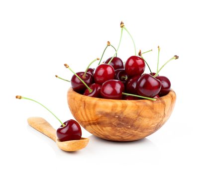 Sweet cherry in a wooden bowl, isolated on white background