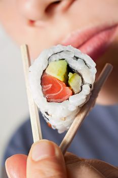 Close-up shot of a person who eats sushi