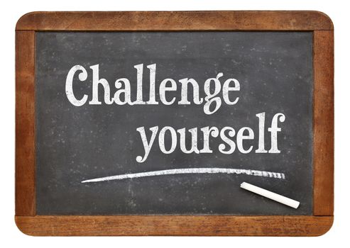 Challenge yourself - motivational text  on a vintage slate blackboard