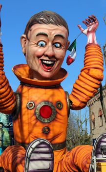 Poggio Renatico, Italy - 01 march 2015: The parade of carnival floats with dancing people on streets. A fake astronaut exults arrival on earth