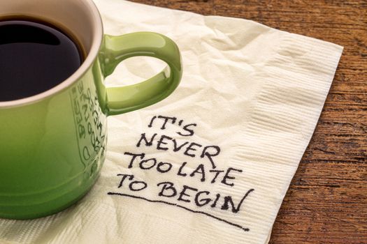 It is never too late to begin - motivational reminder on a napkin with a cup of coffee