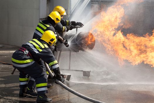 Firefighters attack a propane fire during a training exercise