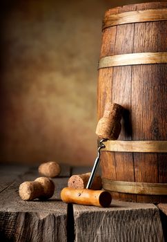 Wooden cask with corks and corkscrew on a table