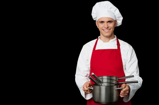 Isolated young male chef posing with empty vessels