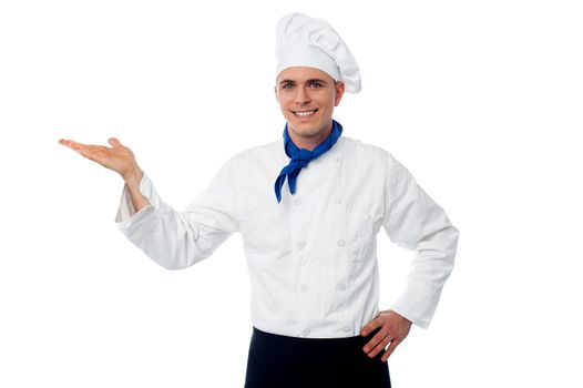 young handsome chef showing something isolated on white background