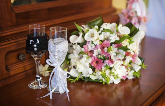 beautiful wedding bouquet and two glasses with champagne.
