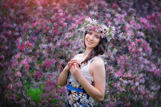 Beautiful girl outdoors spring portrait, young woman with flowers in green park, spring concept. cheerful teenager walking outdoor. series in portfolio