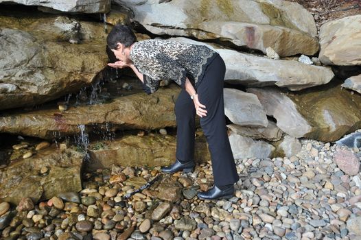 Mature female beauty drinking from the fountain of youth.