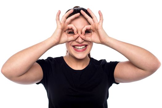 Young woman looking through imaginary binocular