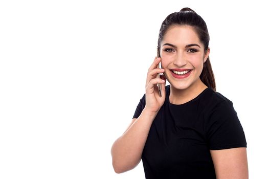 Happy woman talking on cell phone over white