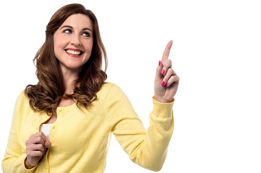 Casual smiling woman pointing up her finger 