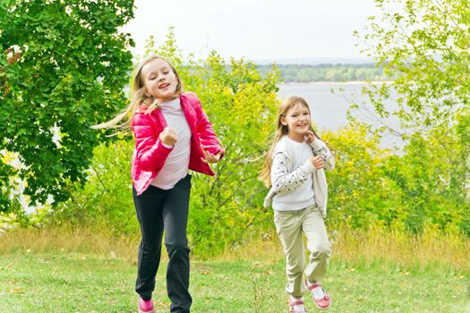 Photo of two running girls in summer